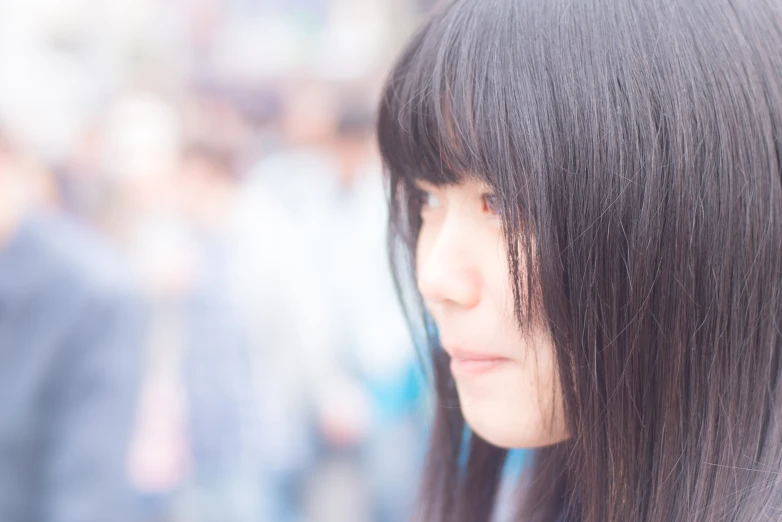 a girl with long, black hair and long bangs looking away from the camera