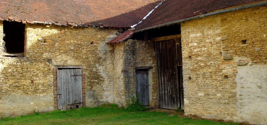 an old building with some doors and brick siding