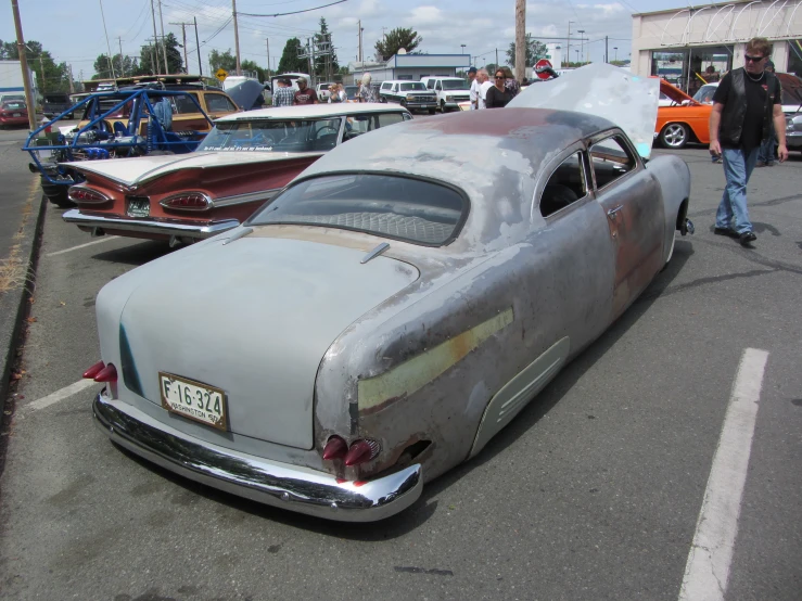 a classic car is in a parking lot with other classic cars