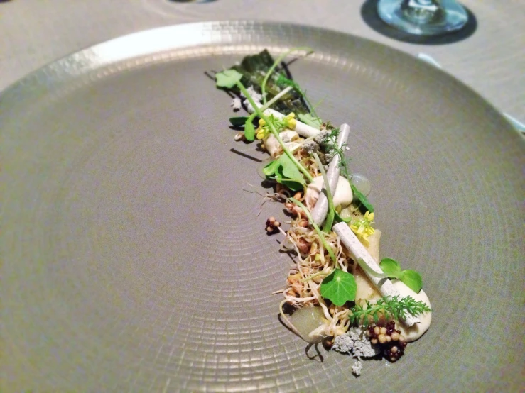 a gray plate with vegetables on it on a table