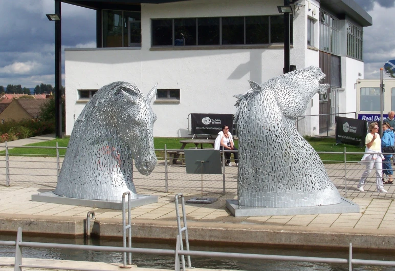 three silver bears sculptures in front of a building