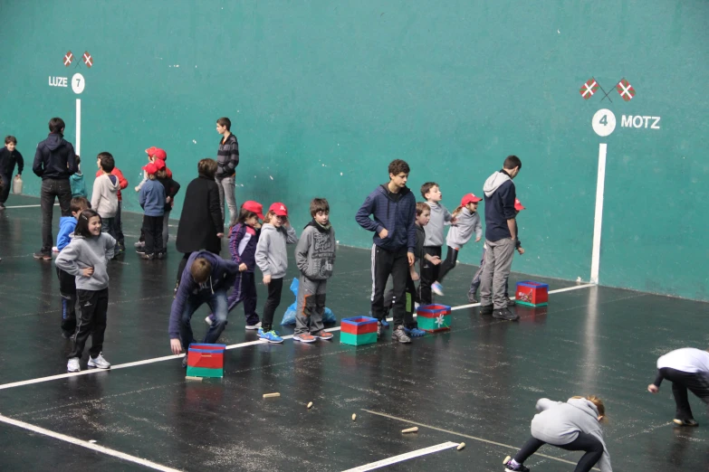 many children are on the tennis court playing