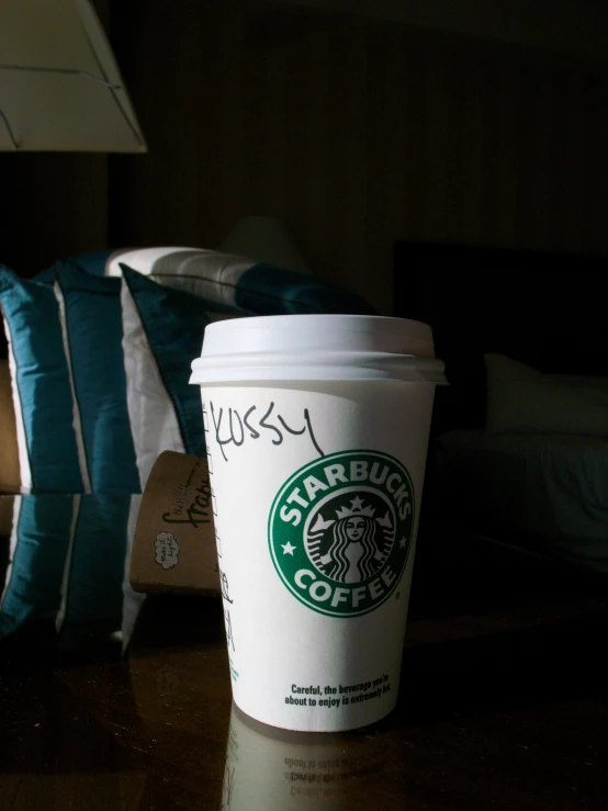 a starbucks coffee cup is on a table next to a stuffed animal