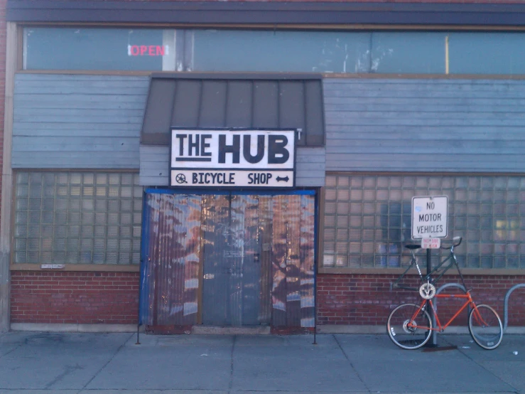 a bicycle sitting next to the front of the hub little shop