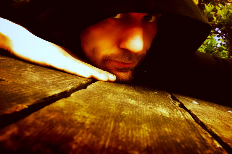 a man leaning on top of a wooden table