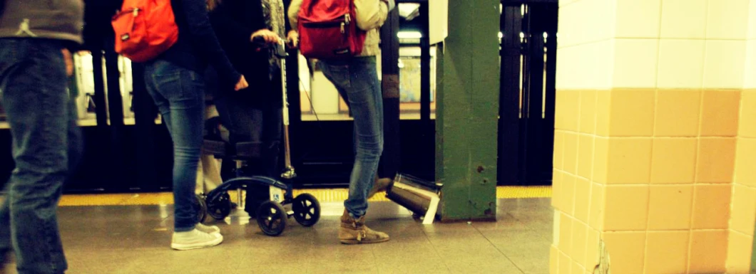 people standing around a subway area and looking at their phone