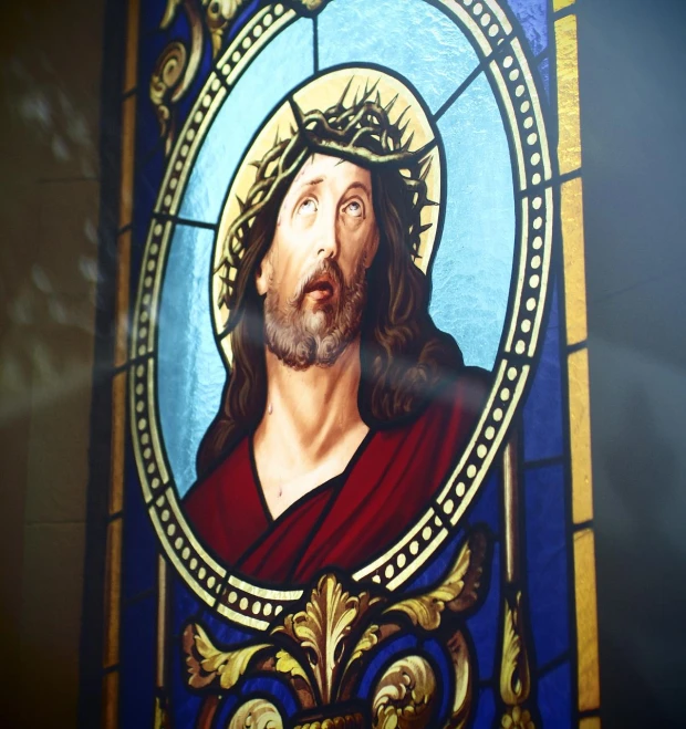 a colorful stained glass window with a religious image on it