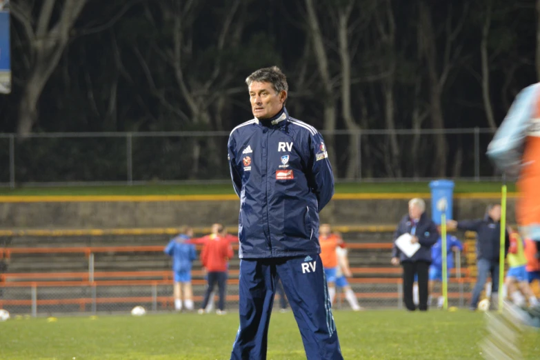 a man in blue is walking around a field