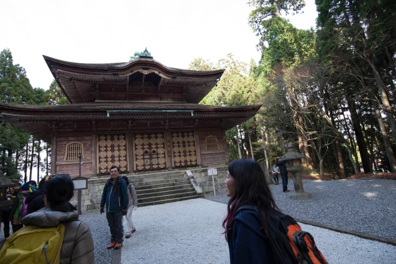 two people walking together in front of a pagoda