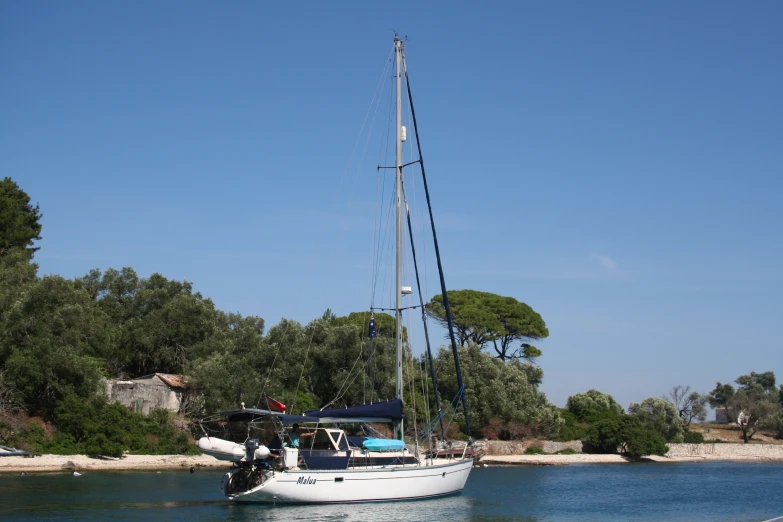 a small white sailboat is out in the water