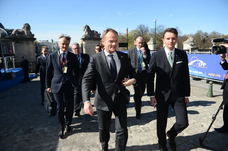 there are a few people in suits walking together