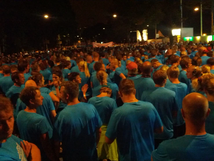 a large crowd of people wearing blue shirts