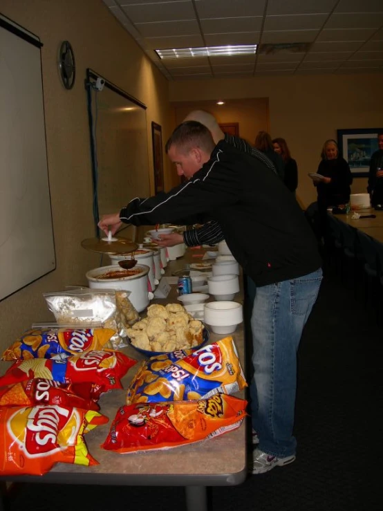 a man reaching into a buffet with food