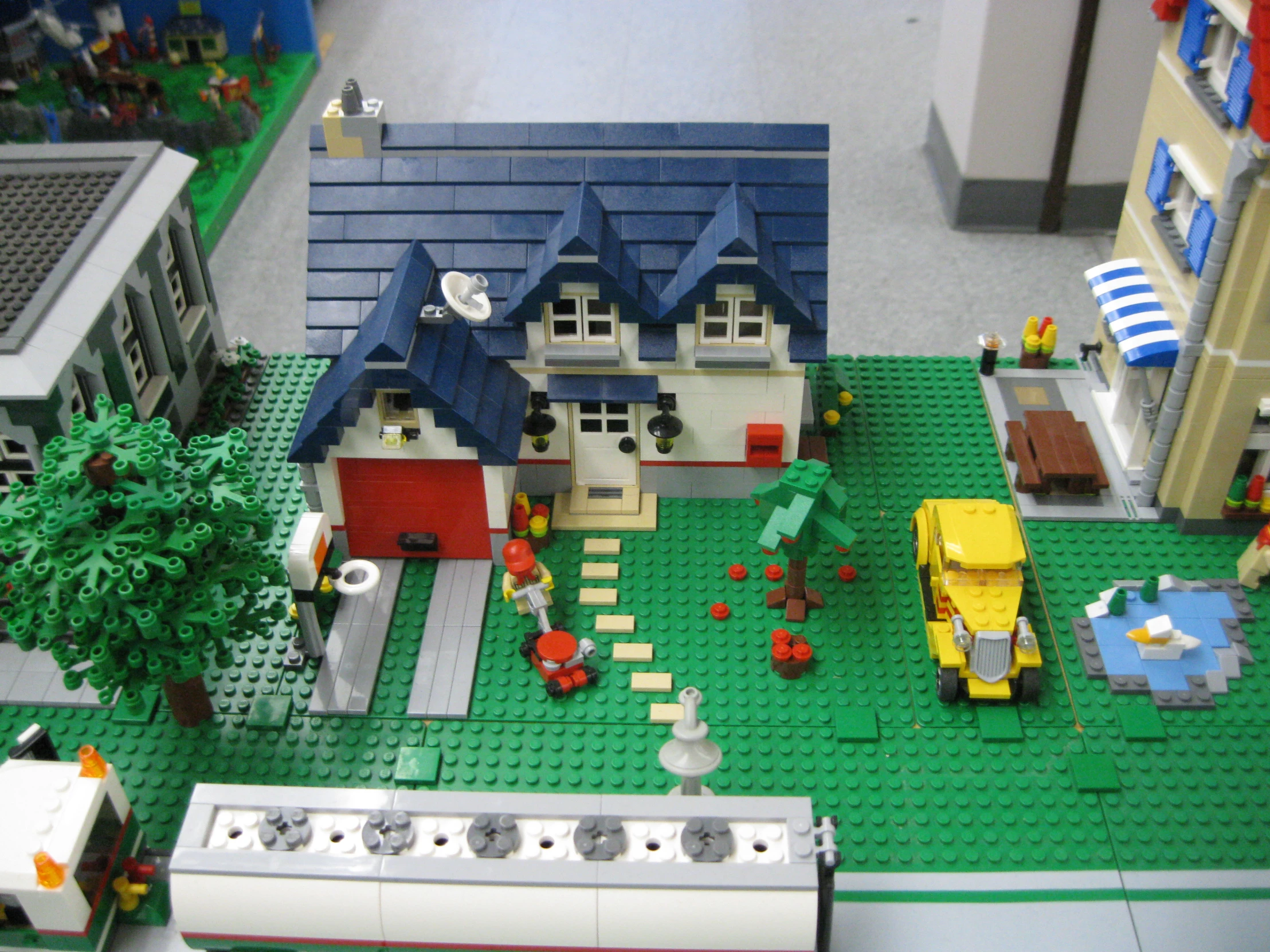 a lego town with lots of houses and people walking