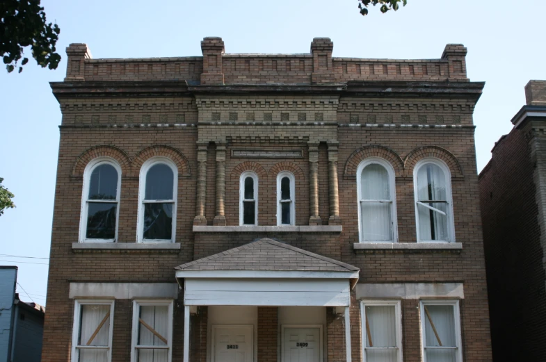 a building with several windows and shutters and an awning