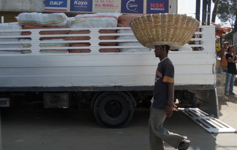 a man in a hat walks by a white truck