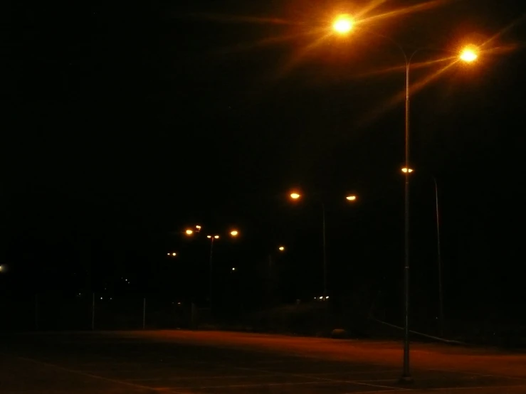 street light pole with street lamps on empty road at night
