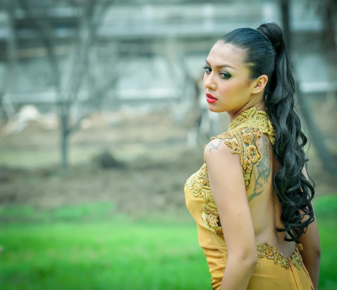 an indian woman poses in a yellow dress