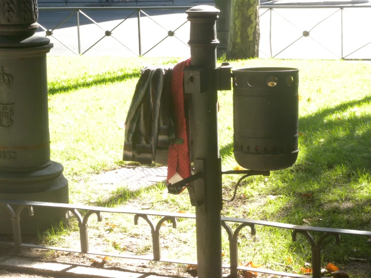 many garbage cans near a fence and some grass