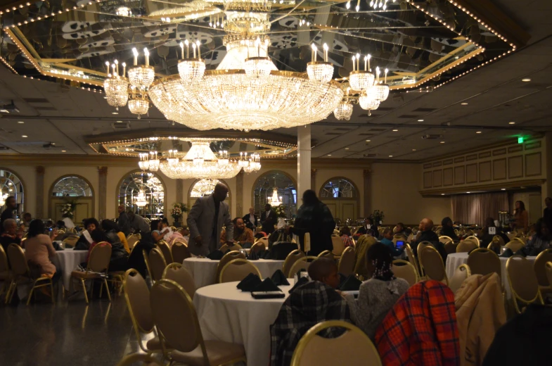 a large room filled with people and fancy chandeliers