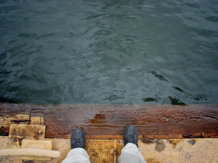 the bottom view of person's feet as they walk into a body of water