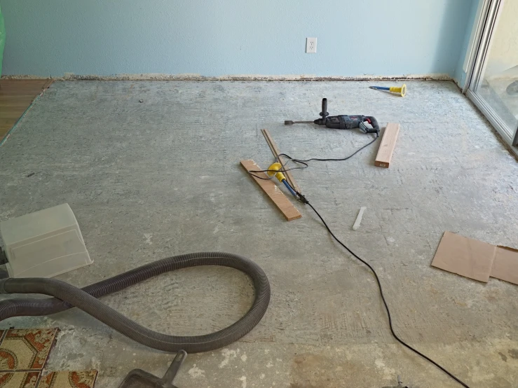 an image of a floor under construction with a drill and cord
