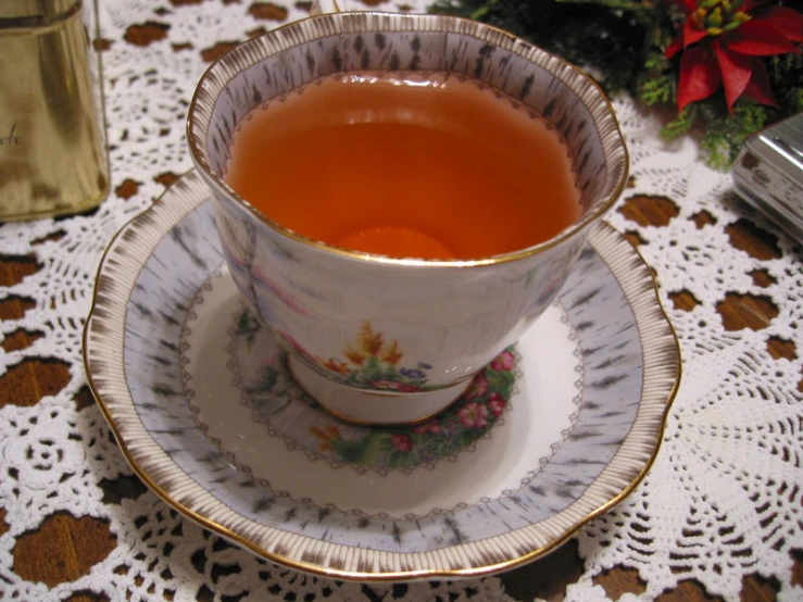 a white and gold china tea cup on a doily