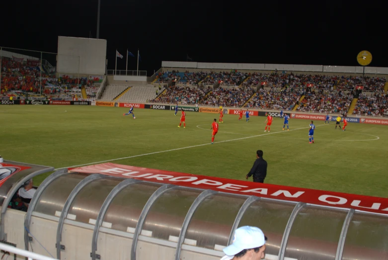 a soccer stadium with people playing soccer in the night