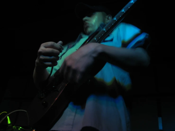 a person is standing with a guitar in the dark