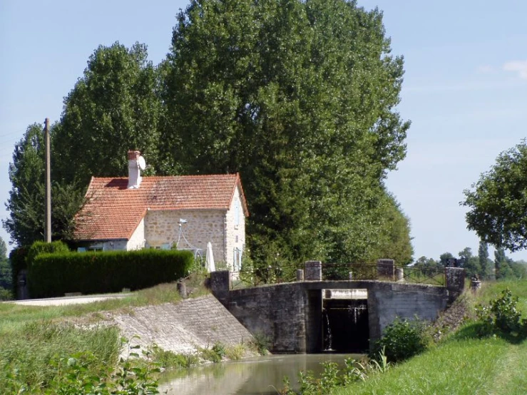 small boat entering the water canal, with a house on the other side