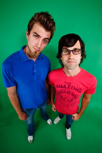 two men posing together for a pograph on a green background