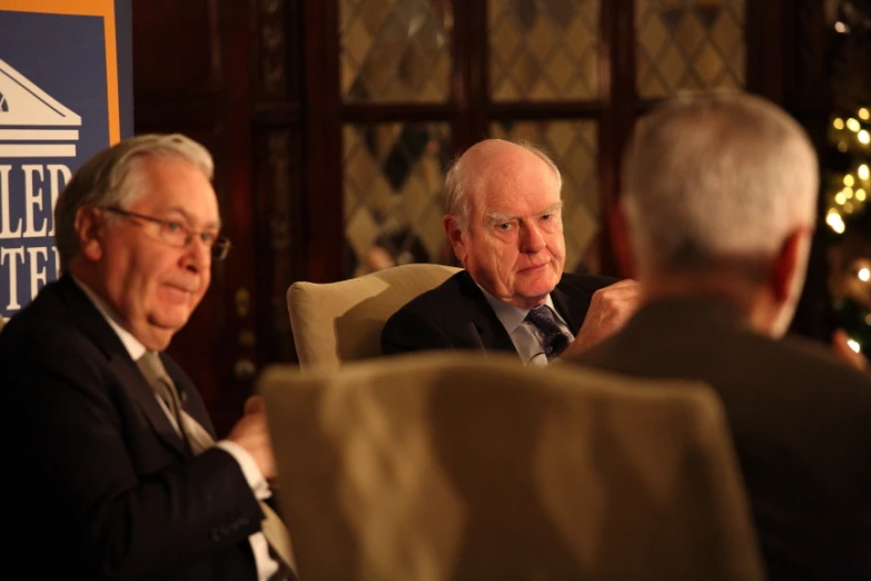 a group of men in business attire sitting at tables