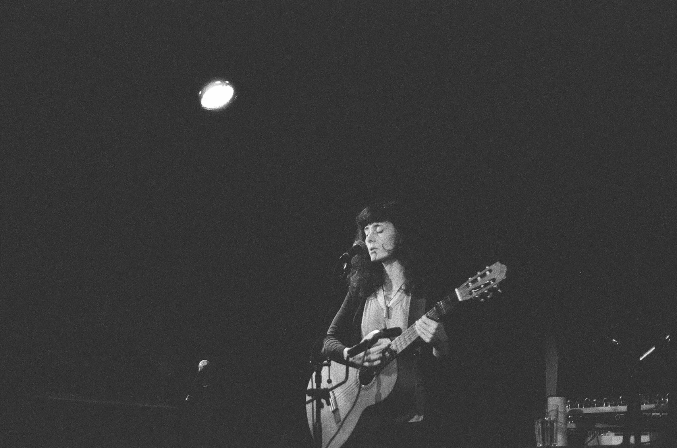 two people are playing guitars in front of the lights