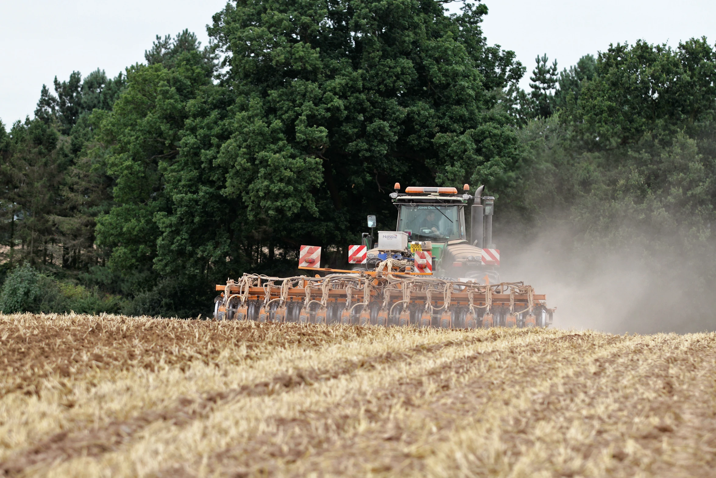 a tractor is driving through a large field of crops