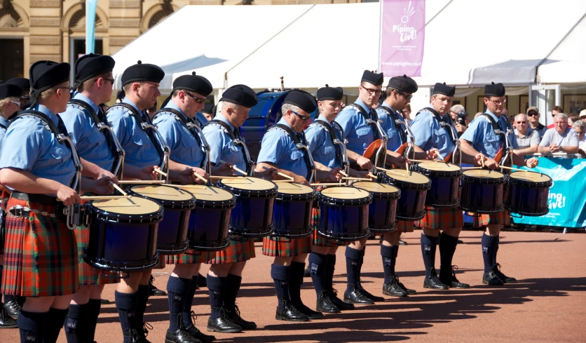 police in kilts and dress clothes playing with drums