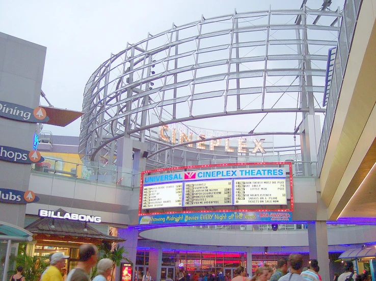 a bunch of people stand in front of the entrance to a theater