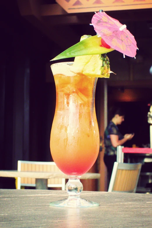 a colorful drink in a glass with an umbrella