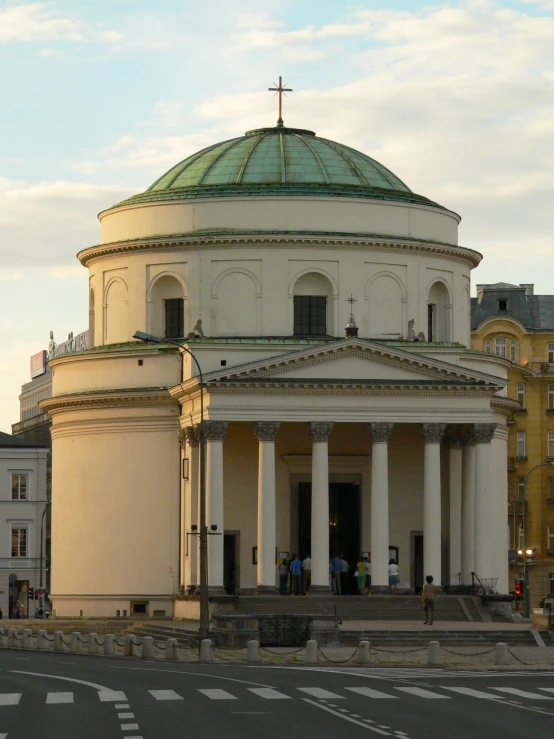 the front view of a white church with a clock tower on top