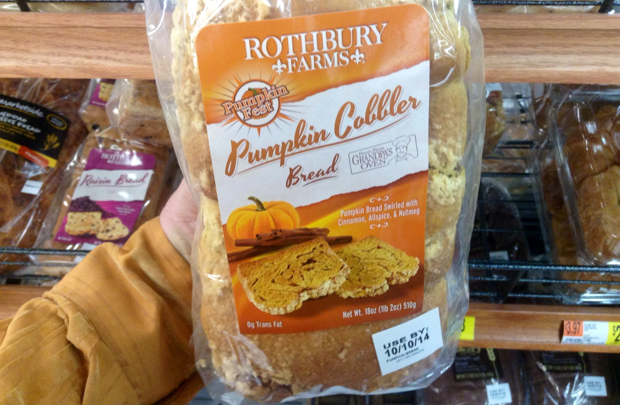 a package of pumpkin cake is being held in front of some shelves