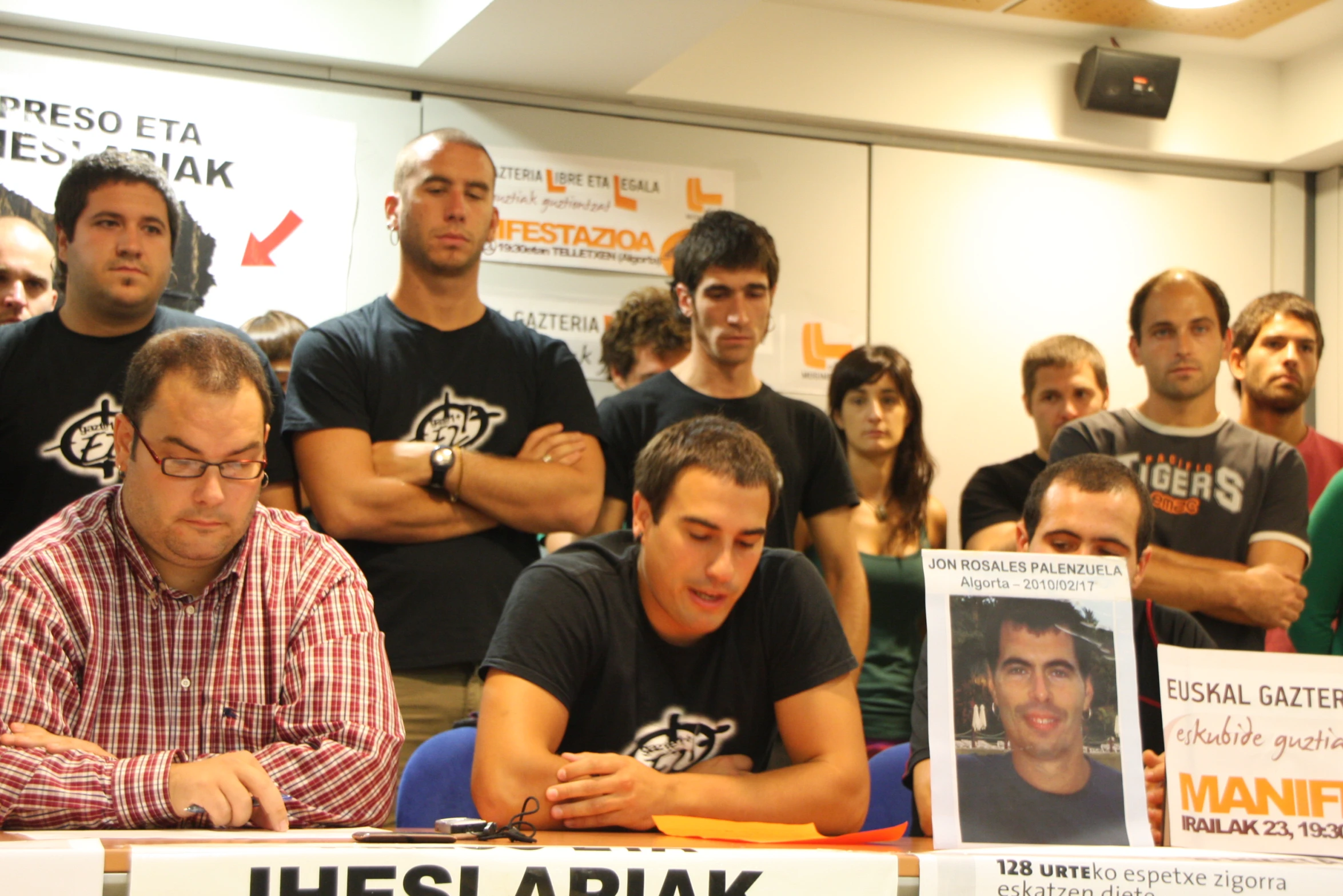 a group of men standing and sitting at a conference room