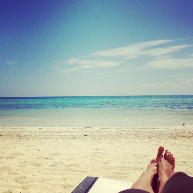 someone is relaxing at the beach on a blanket