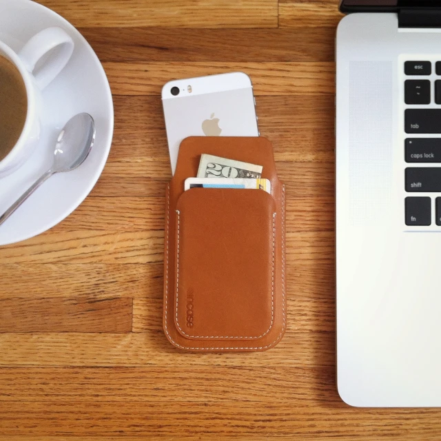 a cup of coffee next to a wallet and laptop computer