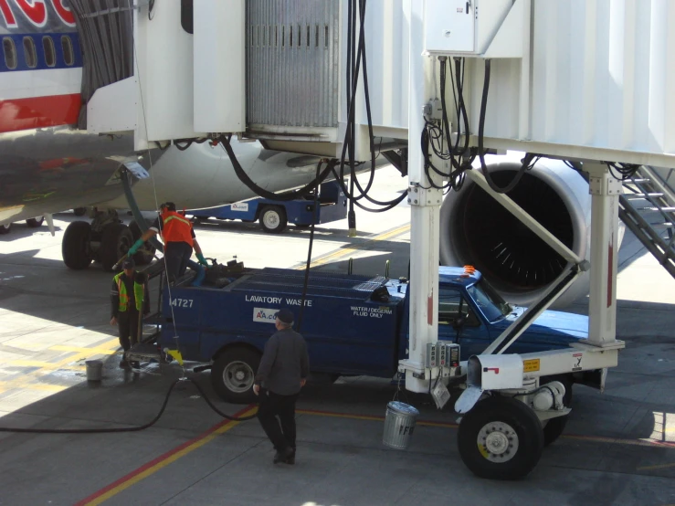 a man in a truck works on the engine of an airplane