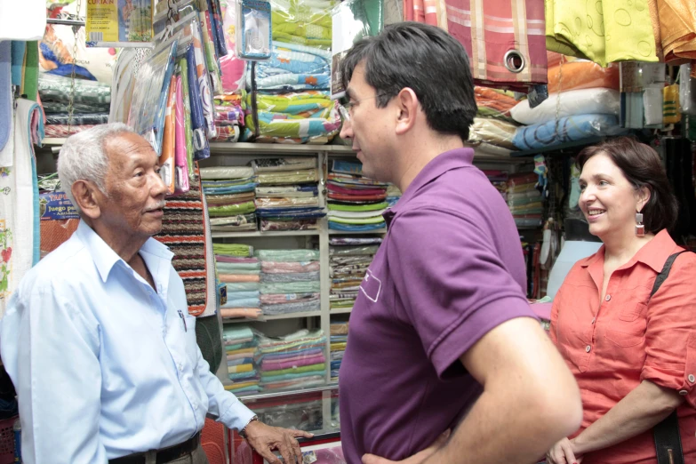 an elderly man and woman are standing in front of a shop