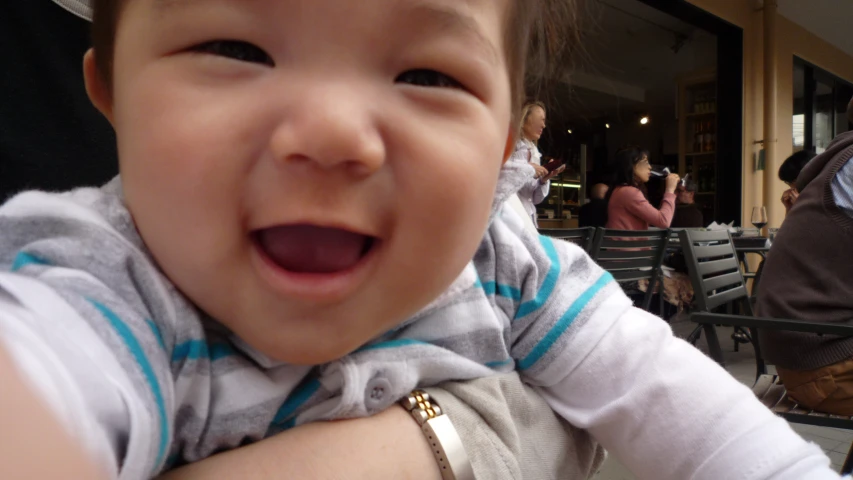 a young child smiling at someone near a crowd