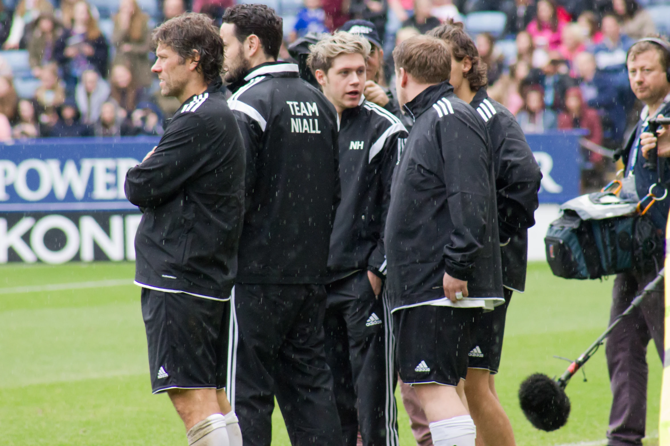 the man in the black jacket talks to his teammates