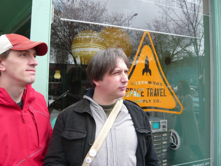 two guys in front of a train station window