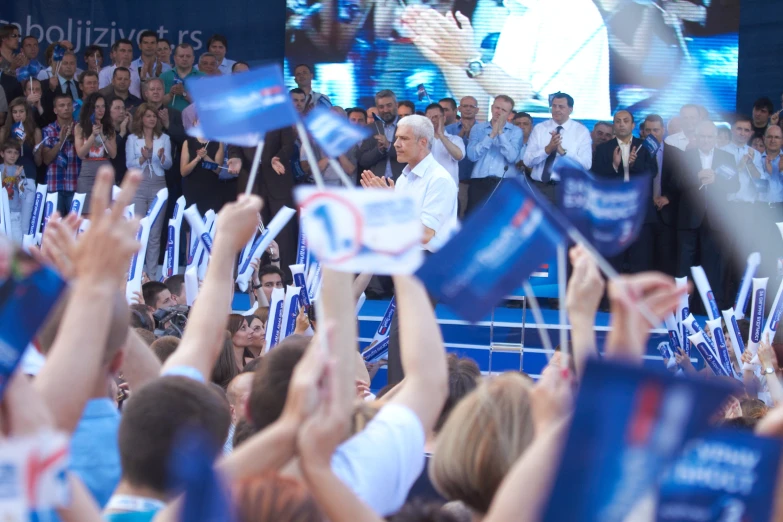 a crowd of people in a stadium holding flags