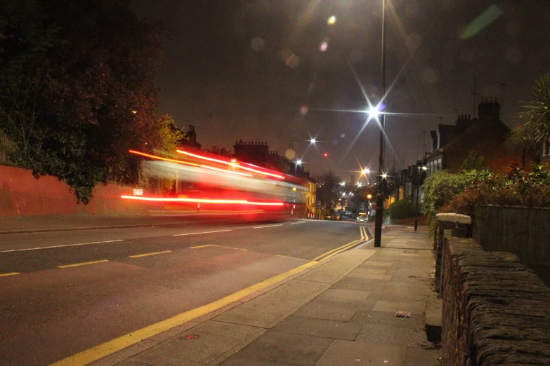 a long exposure image of light trails along the street