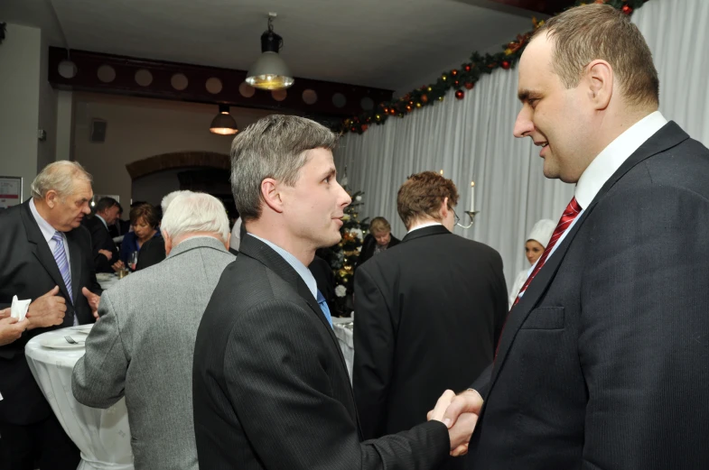 two men standing near each other in business attire